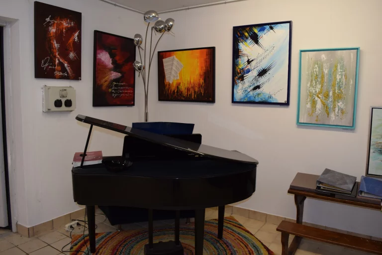 Le coin des artistes est une pièce où les artistes peuvent exposer leurs toiles et jouer un morceau de piano.